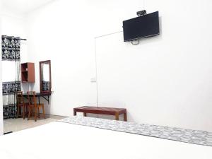 a room with a mirror and a tv on a wall at Mount View Hotel Badulla Room 02 in Badulla