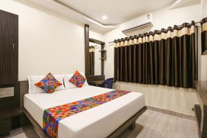a bedroom with a large bed in a room at FabHotel Happy in Vijayawāda