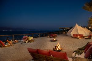 a group of people sitting on a beach with a tent at Glamping -420 in Kalia