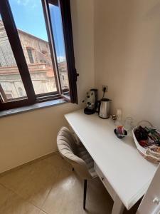 a white desk with a chair in a room with a window at B&B Magliuolo in San Giovanni a Piro