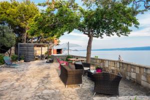 a patio with chairs and a table and a tree at SUPER HORIZONT- Sea View Apartments with private Jacuzzi time & Free Parking in Split