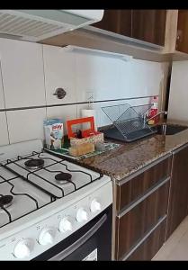 a kitchen with a stove top oven in a kitchen at Departamentos Maxx II in Colón