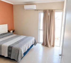 a bedroom with a bed and a window at Departamentos Maxx II in Colón