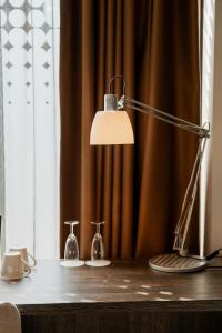 a desk with a lamp and two vases on it at WestCord Hotel Eindhoven in Eindhoven