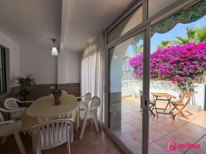 a dining room with a table and chairs and flowers at Bloom House in Oropesa del Mar