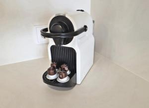 a coffee machine with two chocolateuts on a shelf at BR Silgar Suites in Sanxenxo