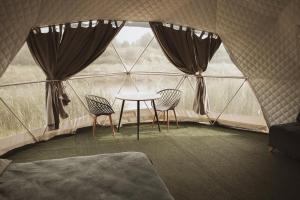 a room with a table and chairs in a tent at Глемпінг Zatuшшя in Berezovka