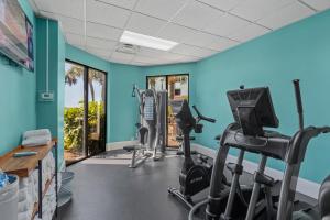 a gym with tread machines in a room with blue walls at The Strand - A Boutique Resort in Myrtle Beach +25 photos