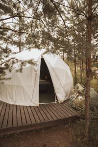 a white tent sitting on a wooden deck at Глемпінг Zatuшшя in Berezovka