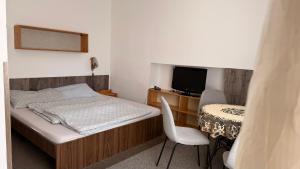 a bedroom with a bed and a desk and a television at Pěkná Vyhlídka in Závažná Poruba