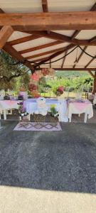a group of tables with flowers on them under a pavilion at Sorres Agriturismo in Tanaunella