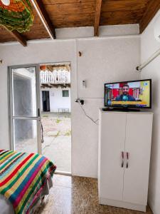 a bedroom with a tv on top of a cabinet at Alojamiento EYO en Chuy con Baño Privado y Aire Acondicionado in Chuy