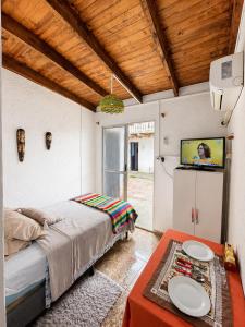 a bedroom with a bed and a flat screen tv at Alojamiento EYO en Chuy con Baño Privado y Aire Acondicionado in Chuy