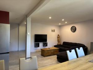 a living room with a couch and a tv at L'estaou in Lavoûte-Chilhac