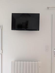 a flat screen tv hanging on a white wall at Studio cozy 2pp wifi in La Sicaudais