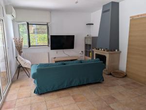 a living room with a blue couch and a tv at Can Altaba in Maçanet de la Selva
