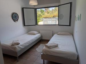 two twin beds in a room with a window at Can Altaba in Maçanet de la Selva