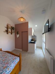 a bedroom with a bed and a small kitchen at Studio cozy 2pp wifi in La Sicaudais