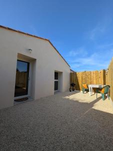 a patio with a table and chairs and a fence at Studio cozy 2pp wifi in La Sicaudais