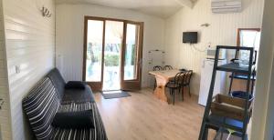 a living room with a couch and a table in a room at Chalet confort 3 piscine partagée in Les Vans