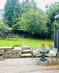 a patio with a table and chairs in a yard at Derbyshire House Apartment 3 - Cavendish in Buxton