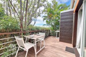 a wooden deck with a table and chairs on it at Aybowan - Jacuzzi - Climatisation in Les Avirons