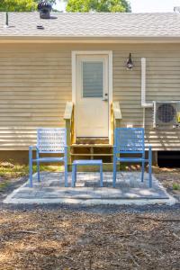 two blue benches sitting in front of a house at Blue Lobster Inn Cape Cod in Yarmouth
