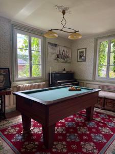 a room with a pool table on a red rug at La tourelle in Vascoeuil