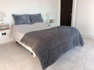 a bedroom with a bed with a gray blanket at Concordia, Entre Rios in Concordia