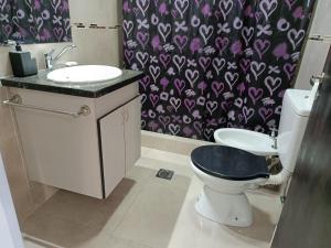 a bathroom with a toilet and a sink with a purple shower curtain at Concordia, Entre Rios in Concordia