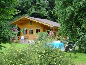eine Blockhütte mit einem Tisch und Stühlen im Hof in der Unterkunft Ferienwohnung Steinebach in Daun