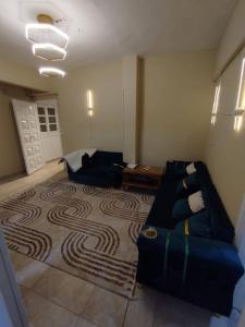a living room with a couch and a carpet at ابراهيم هاوس in Al Ghuşnah