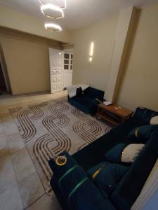 a living room with a couch and a rug at ابراهيم هاوس in Al Ghuşnah