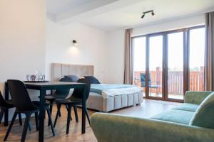 a bedroom with a bed and a table and chairs at Blisko Natury Jacuzzi & Sauna in Pisz +68 photos