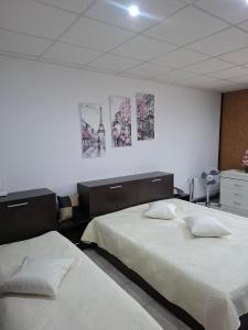 two beds in a room with posters on the wall at Kombfapartment in Berkovitsa