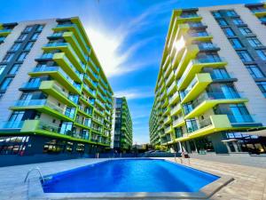 a swimming pool in front of two tall buildings at Alezzi Luxury Double Studio - Beach Pool & Spa Resort in Mamaia Sat/Năvodari