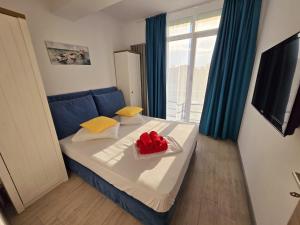 a bedroom with a blue bed with a tray of red peppers at Alezzi Luxury Double Studio - Beach Pool & Spa Resort in Mamaia Sat/Năvodari +31 photos