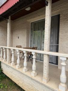 a balcony with a table and chairs on a house at Kombfapartment in Berkovitsa