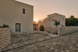 a house with a stone fence next to a building at Taria Resort in Poreč