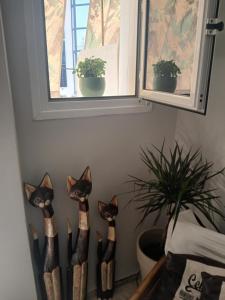 a group of four cat statues in a corner next to a window at Αγγελικη in Kyparissia