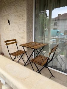 a wooden table and two chairs on a balcony at Kombfapartment in Berkovitsa