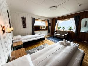 a living room with two beds and a couch at Svingen Guesthouse - Panoramic Fjord Views in Flåm in Flåm