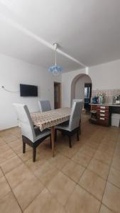 a dining table and chairs in a living room at La Flower Nesvady in Nesvady