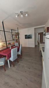 a kitchen and dining room with a red table and chairs at La Flower Nesvady in Nesvady