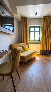 a living room with a couch and yellow curtains at Zaspany Piec in Mikołajki