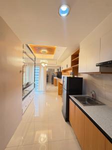 a kitchen with a sink and a refrigerator at Inspiria Condominium in Davao City