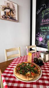 a pizza on a table with a red and white table cloth at Zaspany Piec in Mikołajki