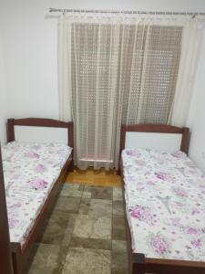 zwei Einzelbetten in einem Zimmer mit Fenster in der Unterkunft Bane apt in Kravlja + 7 Fotos