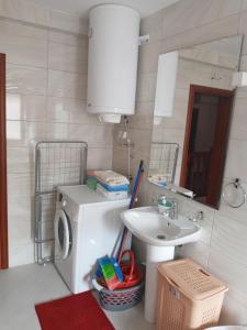 ein Badezimmer mit Waschmaschine und Waschbecken in der Unterkunft Bane apt in Kravlja