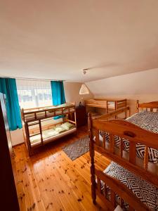 a bedroom with two bunk beds and blue curtains at Dom wczasowy Riviera in Ustronie Morskie